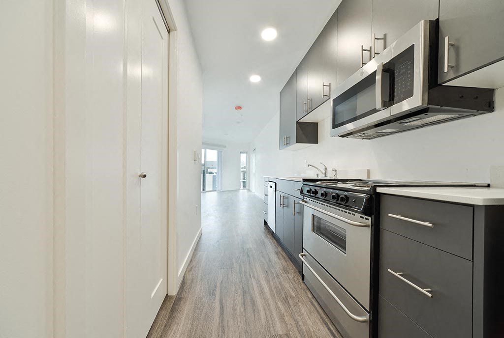 a kitchen with a stove top oven next to a microwave