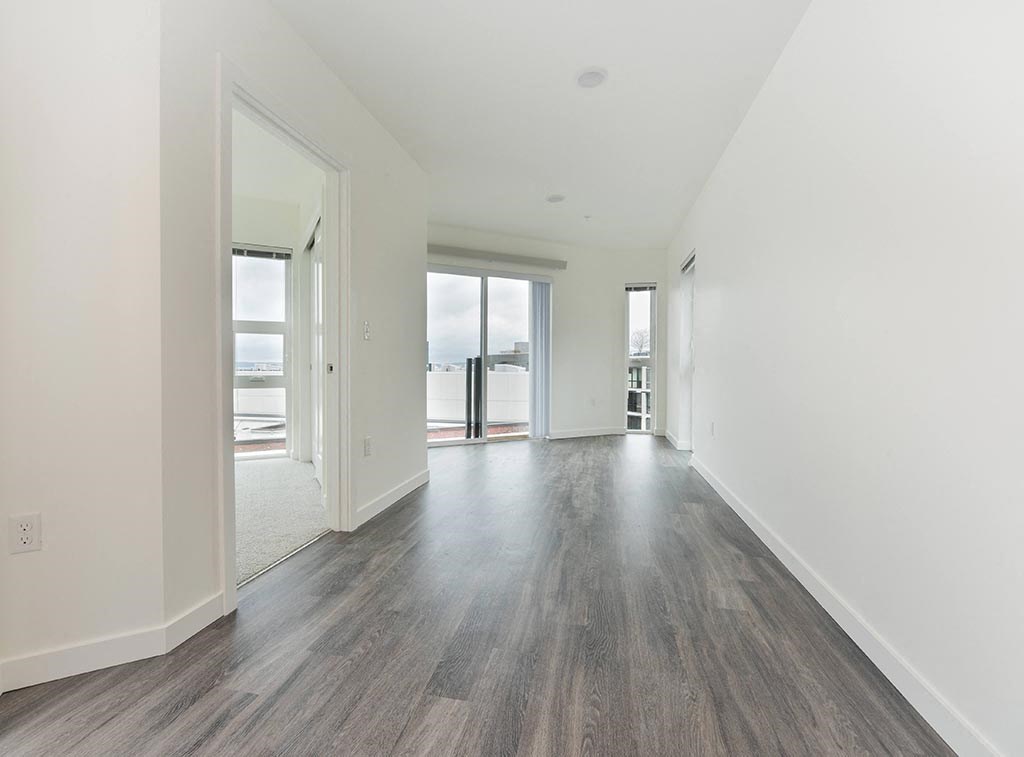 a bedroom with hardwood floors and white walls