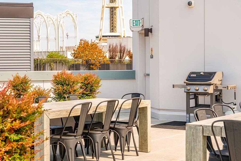 a barbecue grill and tables on the patio of a hotel