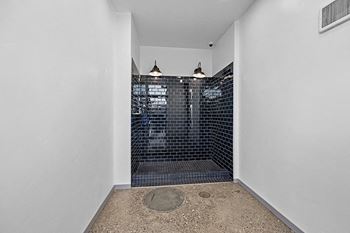 the bathroom has a large tiled shower in the corner of the room