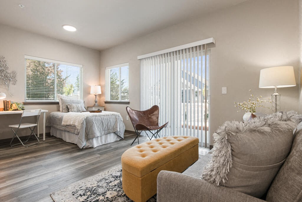 a bedroom with a bed and a living room with a couch