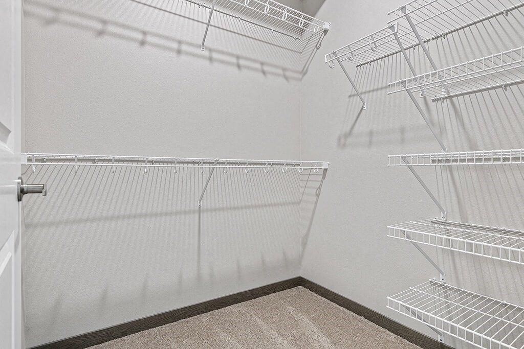 the walk in closet in the master bedroom of an apartment