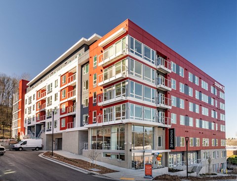 A modern multi-story building with a red and white facade.