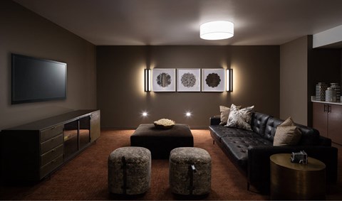 A modern living room with a black couch, a television, and a coffee table.