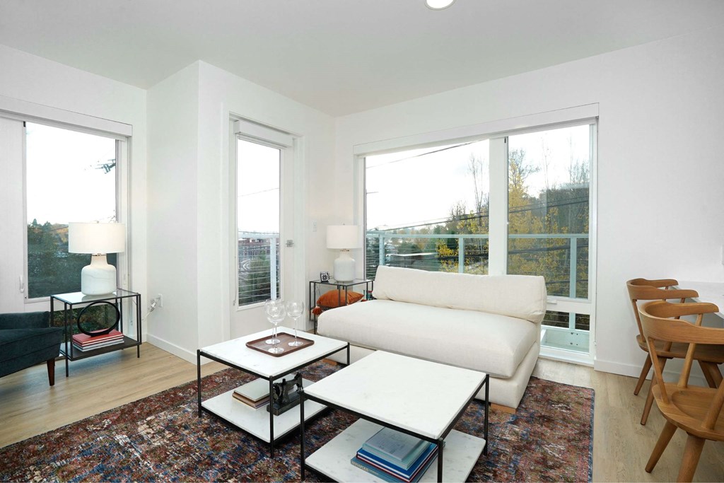 A living room with a white couch, a coffee table, and a rug.