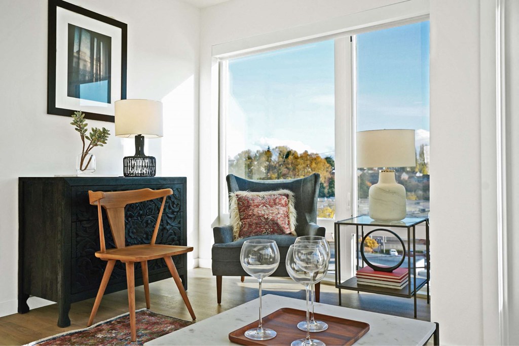 A living room with a wooden chair and a glass table.