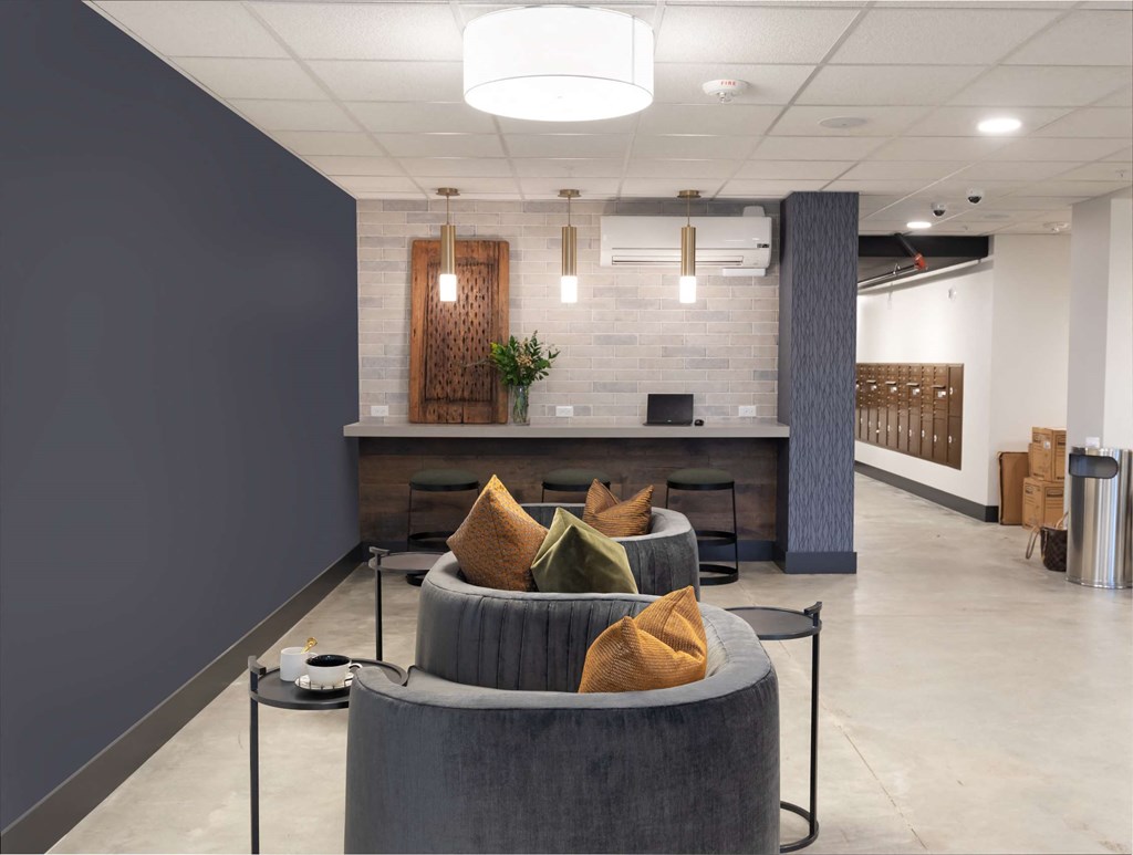 A modern living room with a grey couch and a grey coffee table.