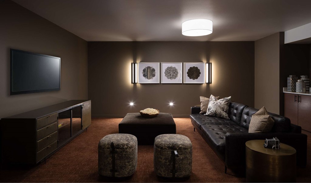 A modern living room with a black couch, a television, and a coffee table.