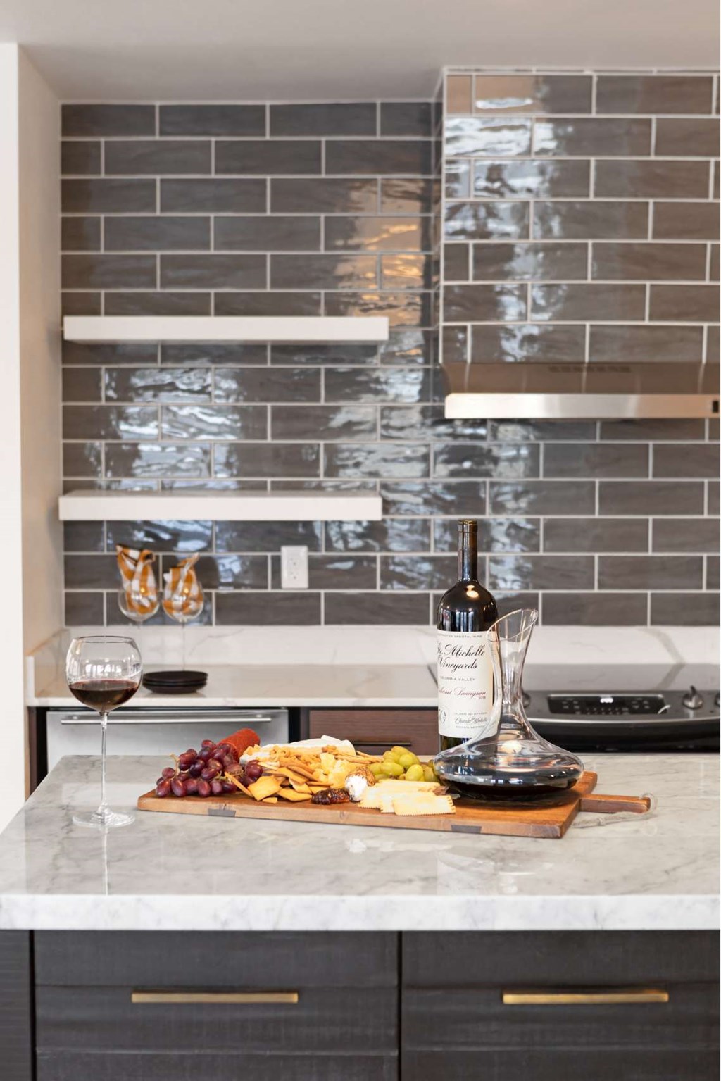 A kitchen counter with a wine bottle and glasses on it.