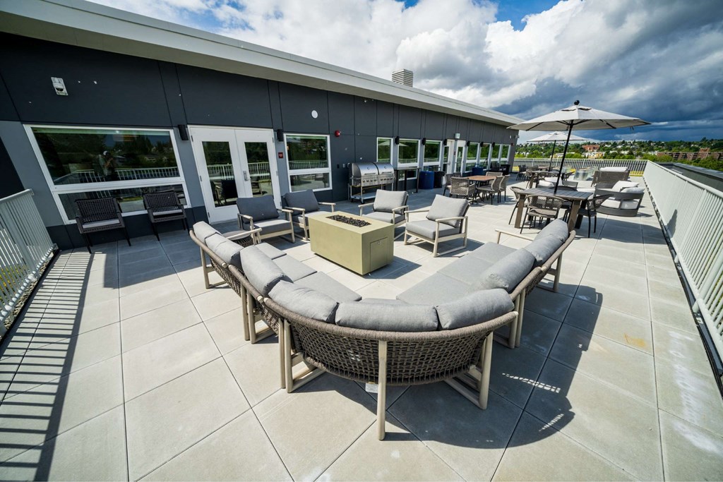 A patio with a table and chairs and a white umbrella.