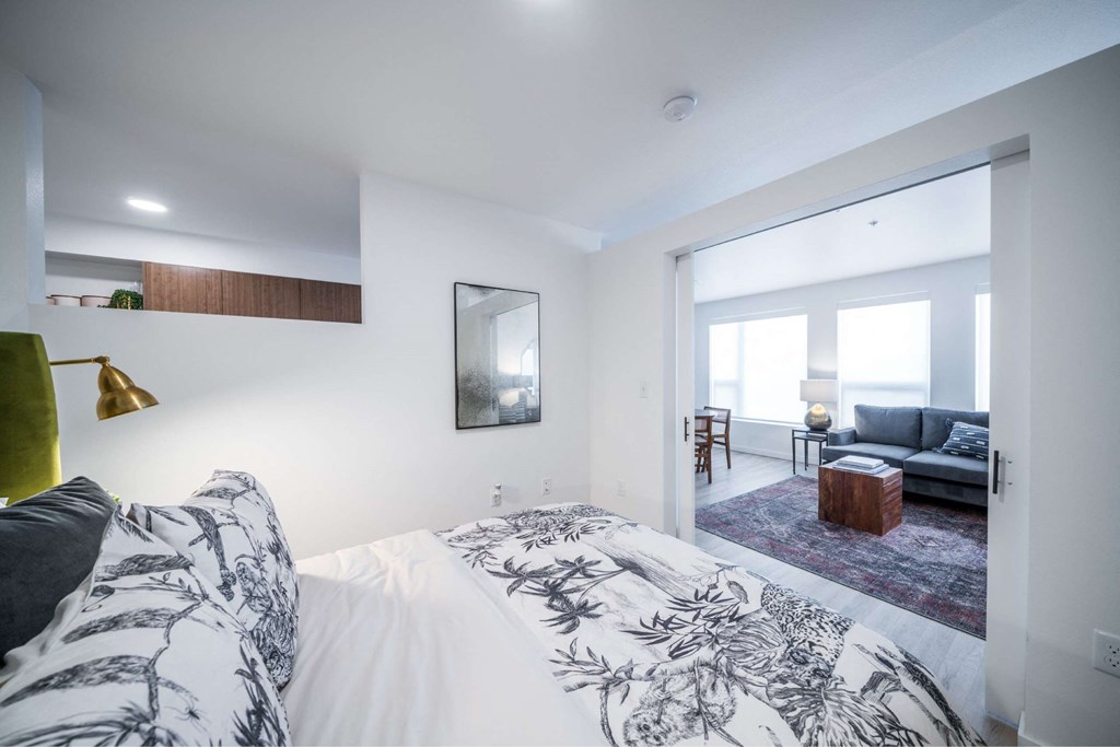 A bedroom with a large bed and a mirror on the wall.