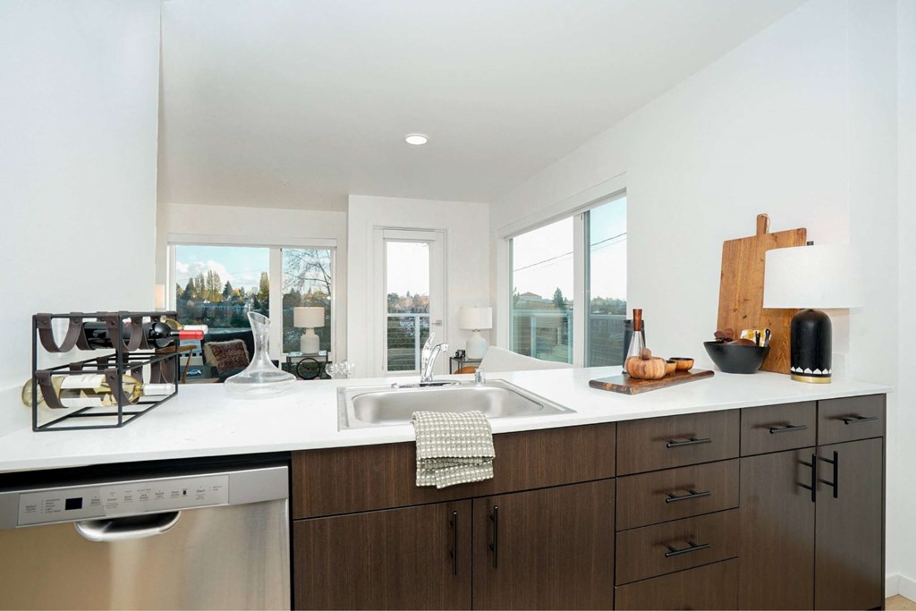 A modern kitchen with dark wood cabinets and a white countertop.