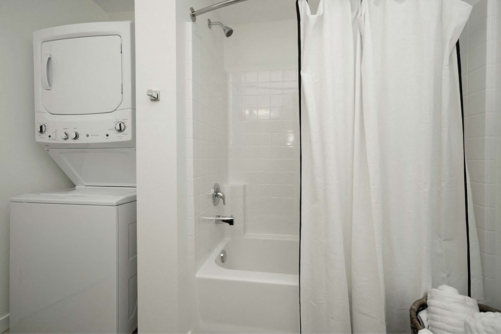 A white bathroom with a toilet, sink, and bathtub.