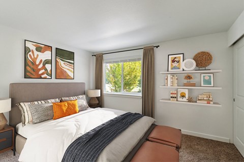 A bedroom with a large bed and a window with a view of trees.