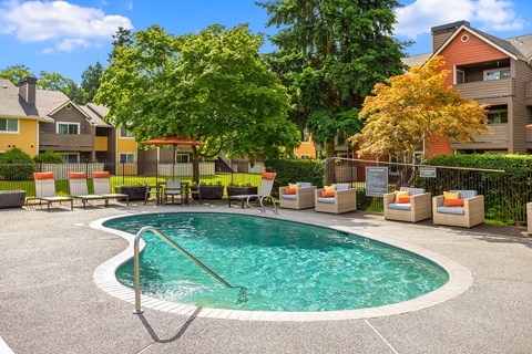 a swimming pool with chairs and a house in the background