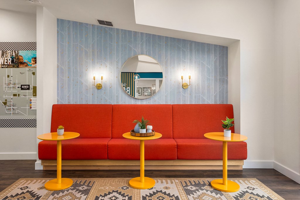 a living room with a red couch and two yellow tables