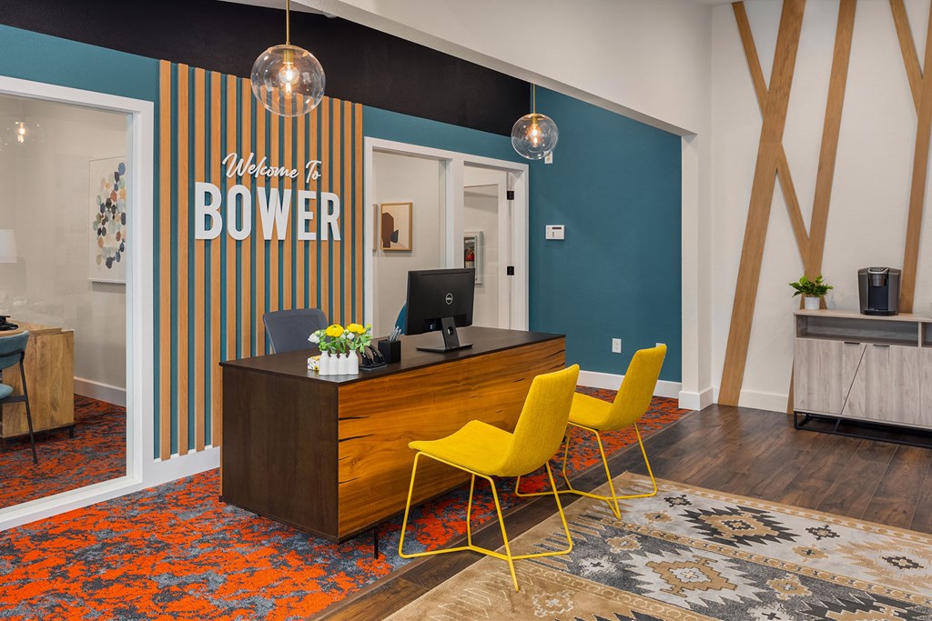 a home office with a wooden desk and yellow chairs