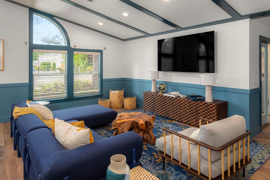 a living room with blue furniture and a large window