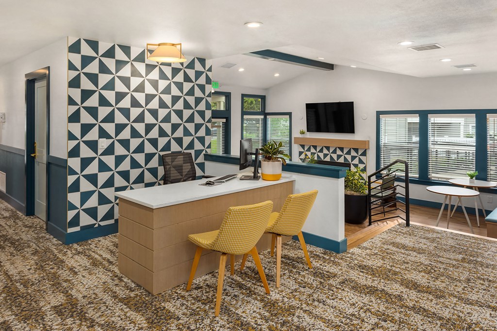 a room with a desk and chairs and a wall with a geometric design