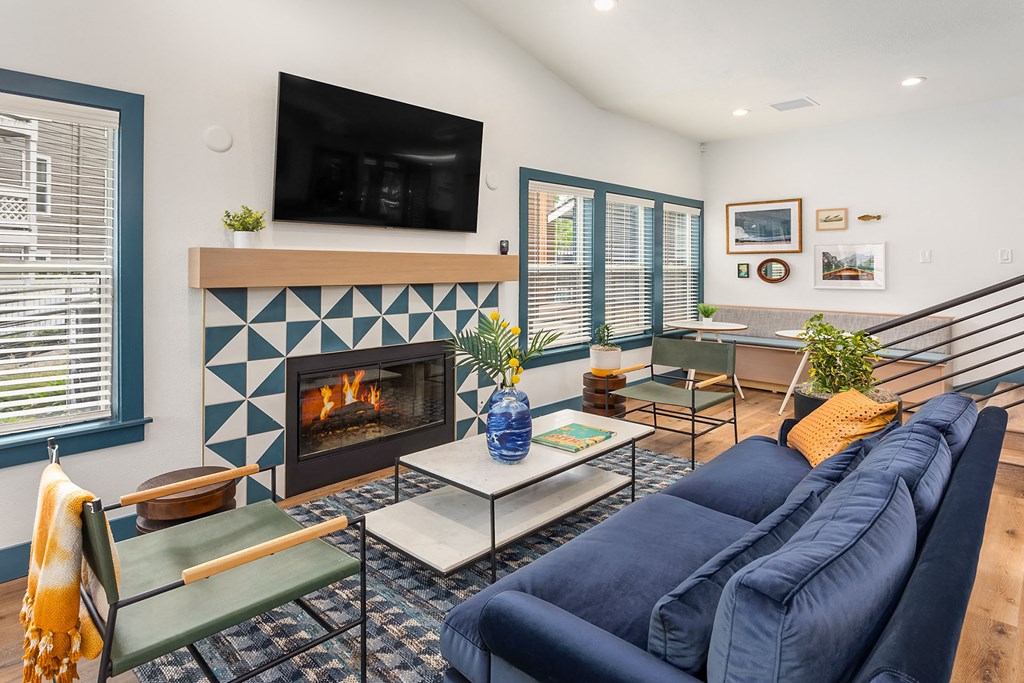 a living room with a blue couch and a fireplace