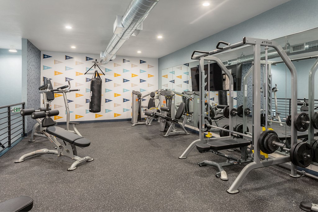 a gym with weights and other equipment in a building with white walls