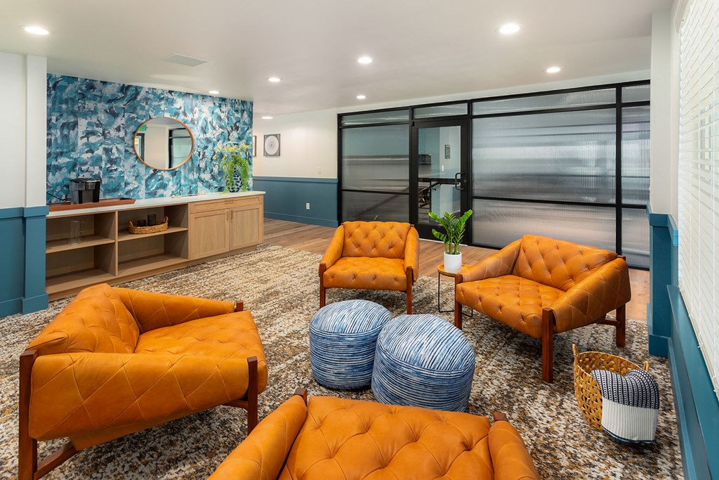 a living room with orange chairs and a blue and white wall