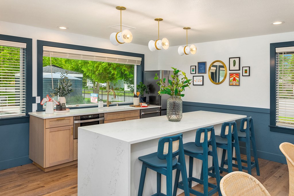 a kitchen with a large island and blue chairs