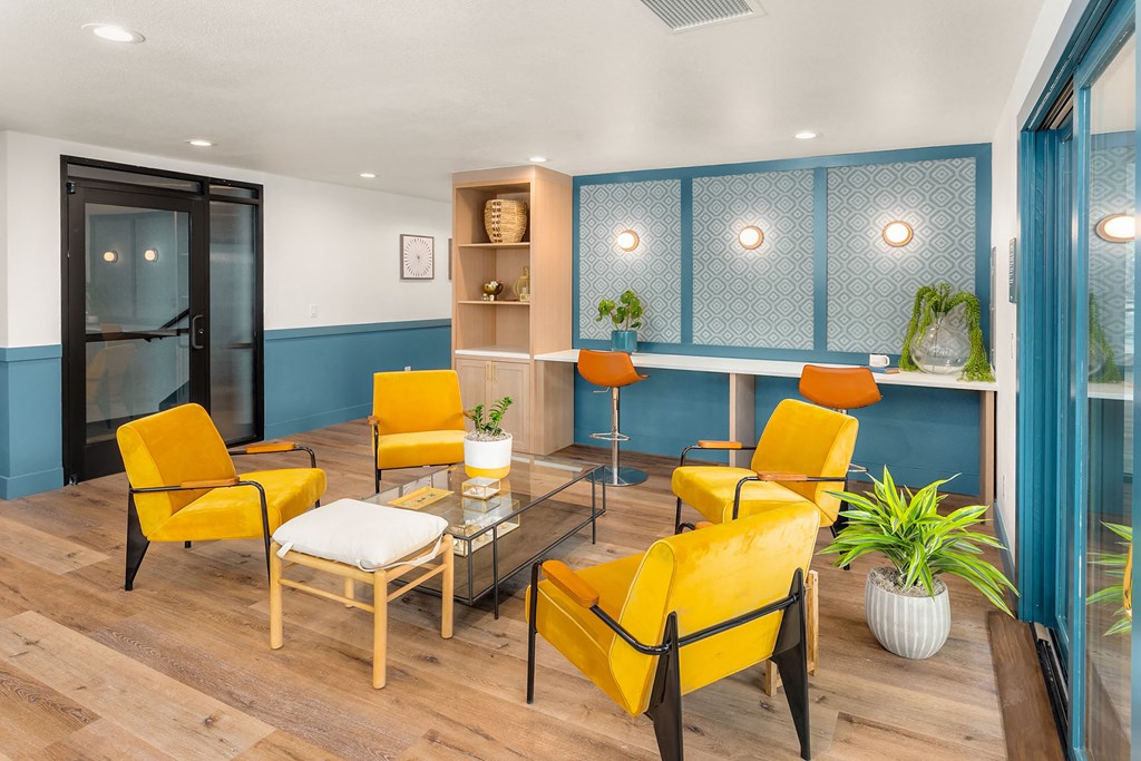 a living room with yellow chairs and a glass table