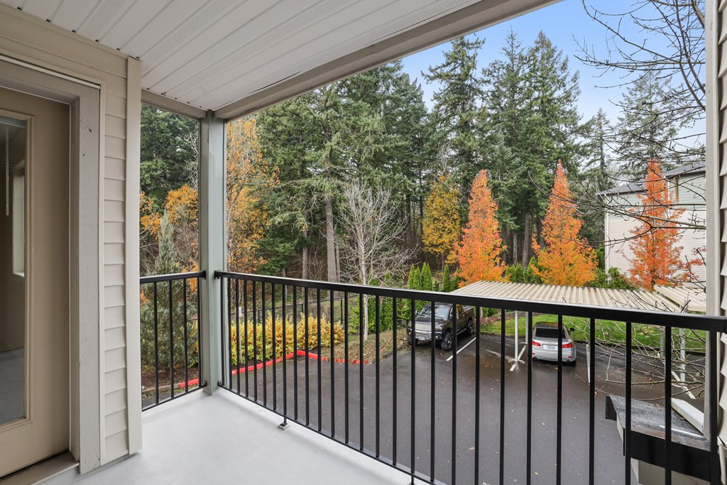 a balcony with a view of a forest and a car parked on it