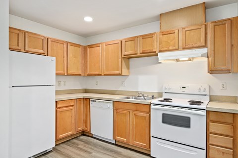 A kitchen with wooden cabinets and white appliances.