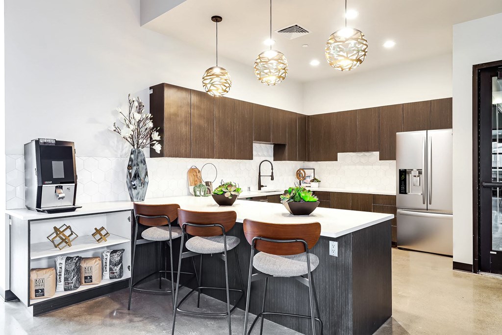 a kitchen with a large island with three chairs