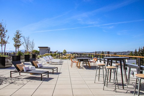A patio with chairs and tables overlooking a city.