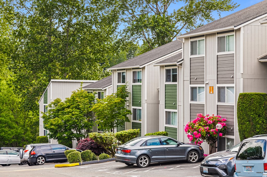 a parking lot with cars in front of an apartment building