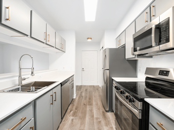 A modern kitchen with stainless steel appliances and wooden floors.