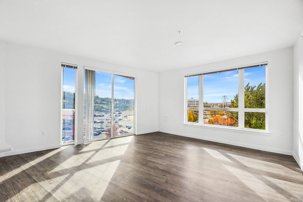 an empty living room with a view of the city from the window