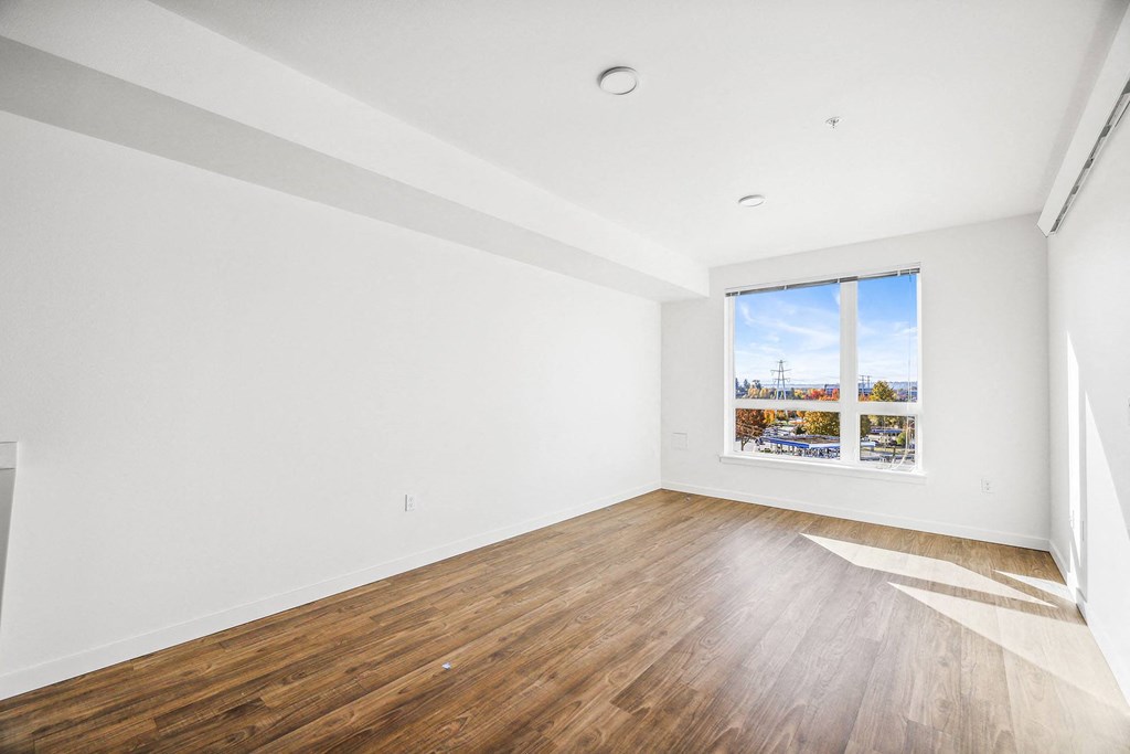 an empty room with wood floors and a window