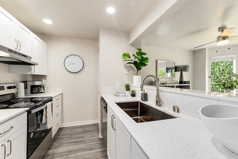 an open kitchen with white cabinets and white quartz counter tops