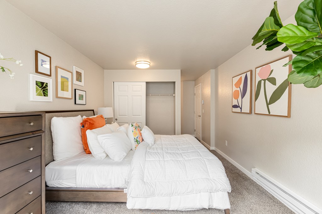a bedroom with white bedding and colorful pillows
