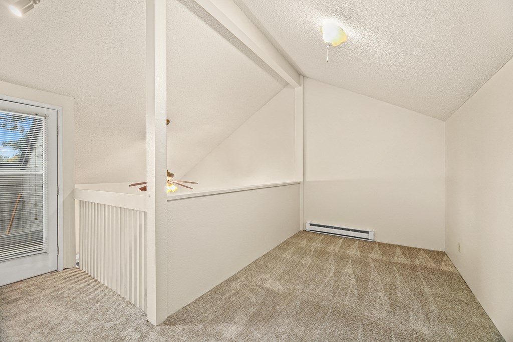 the living room and dining room of a renovated house with a door to a balcony