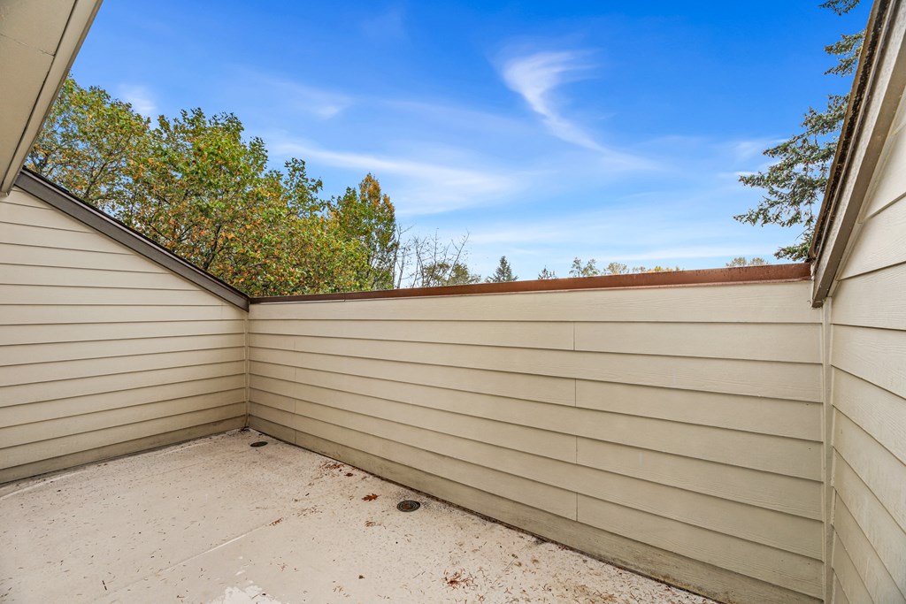 the garage of a house with a white wall and a blue sky