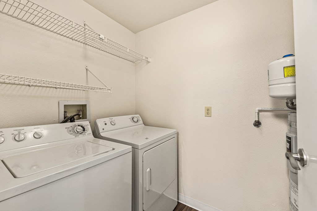 the laundry room has a washer and dryer and a shelf above the sink