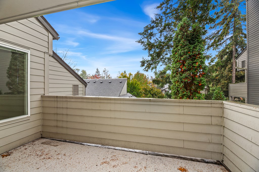 the backyard has a privacy wall with a roof and a tree