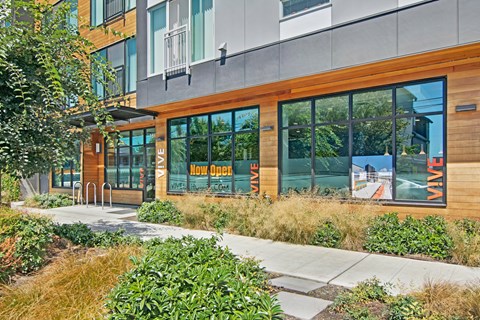 A building with a glass door and windows with the words "Now Open" on it.