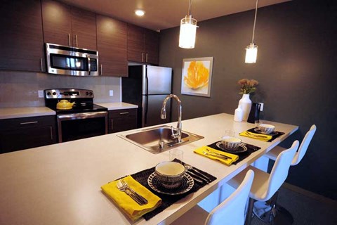 A modern kitchen with a white countertop and black and white place mats.