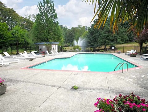 a swimming pool with chairs and a water fountain