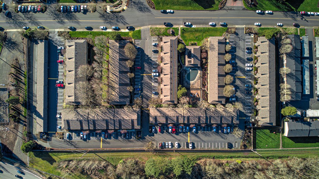 an aerial view of cars parked in a parking lot next to buildings