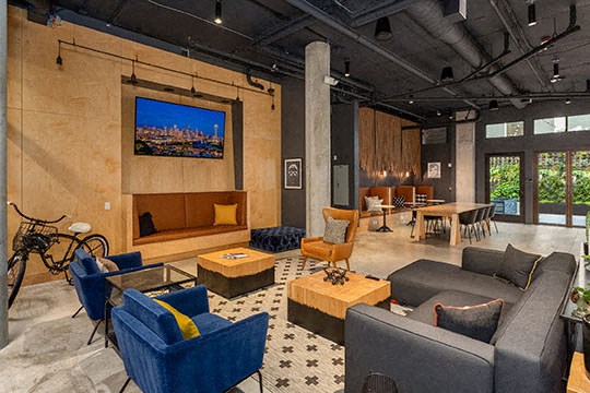 The Jack Apartment lounge has plenty of couch seats and televisions to watch.