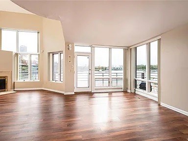A room with wooden floors and large windows.