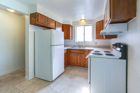 A kitchen with a white refrigerator and a white stove top oven.