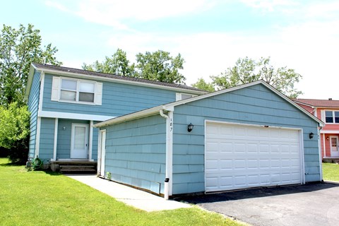 A blue house with a white garage door.
